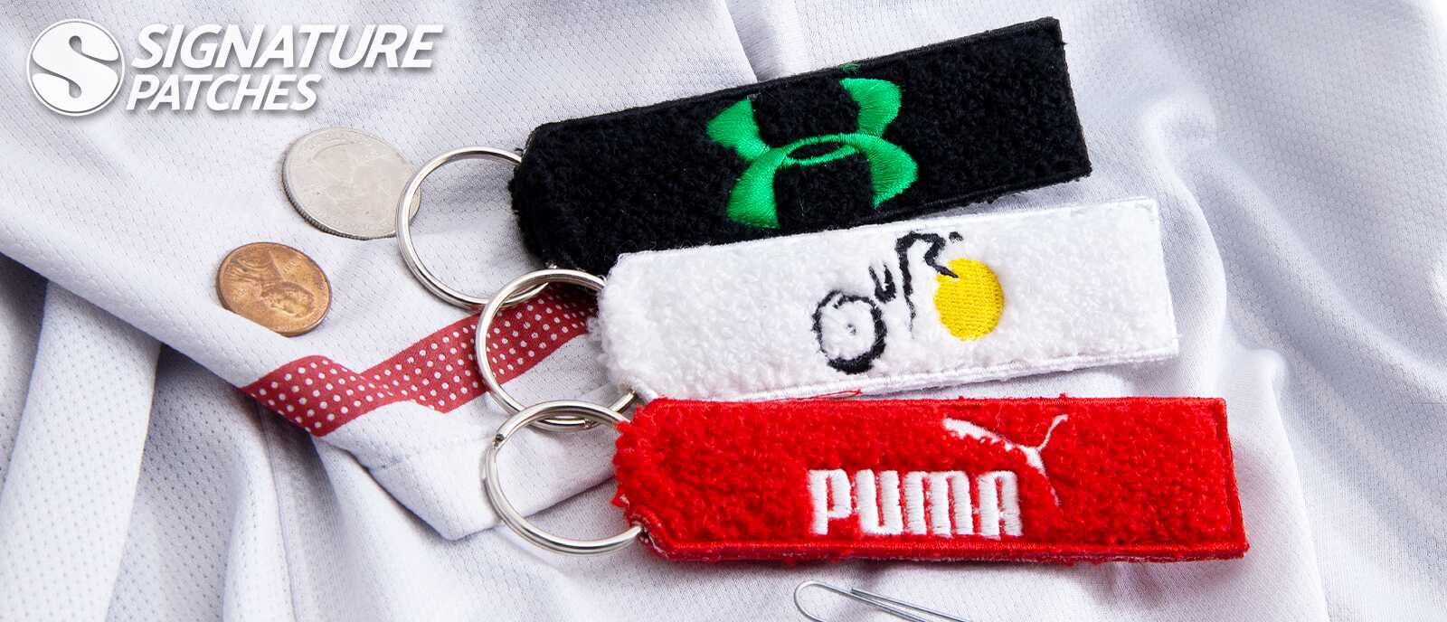 Chenille keychains featuring brand logos including Under Armour and Puma