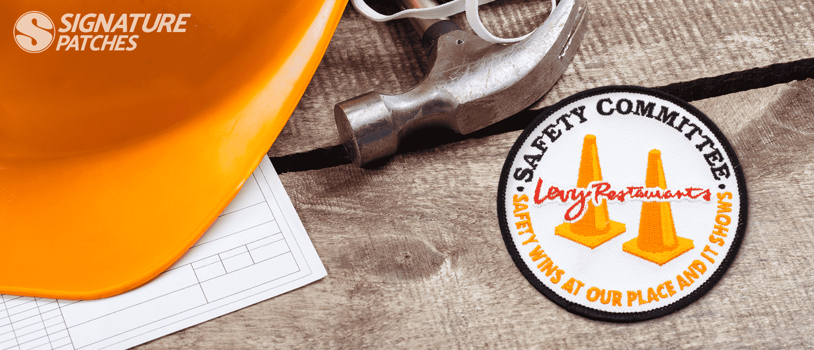 Safety Committee patch with orange traffic cones next to hard hat and tools