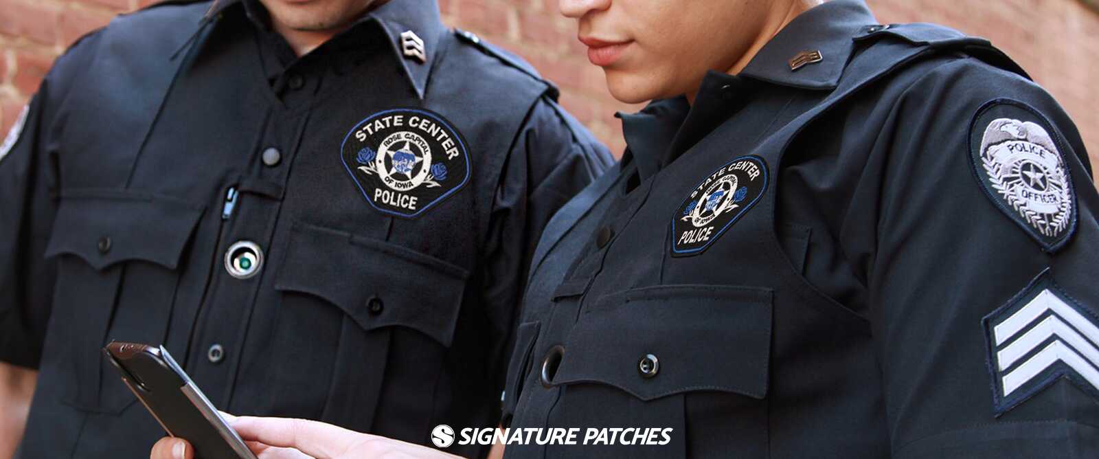 Two police officers wearing custom State Center Iowa Police uniform patches